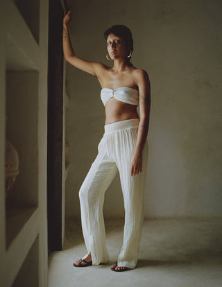 Elevate your holiday wardrobe with Anaak's Imane Pants. This piece of clothing comes in a natural shape of white and it's made from pure cotton, featuring a high-rise and an elasticated waistband. What differentiates Anaak's garments stands out from the rest because they are contemporary, but ancient textile processes are still used to make them. The design is airy for effortless and comfortable vacation wear. 