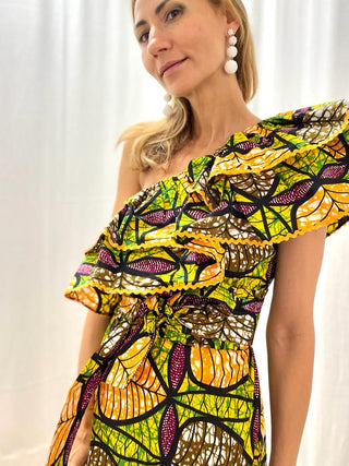 A dress that screams 'Africa'! 100% made in Africa from pure cotton, this dress features a rather tight fit at the waist that flares out over the skirt. What makes it unique is the shoulder detail, the two frills make it extremely playful and perfect for your everyday life. 