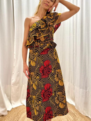 An ode to African culture and to the designer's grandmother, who made wonderful outfits for herself and her grandchildren. Billie is a homage to her with the manufacture of beautiful everyday dresses inspired by the 1970s. This dress features a floral print with a one-shoulder neckline and two side pockets. The neckline is made from volants, that give volume and add a playful touch to the dress.