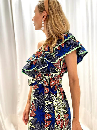 A dress that screams 'Africa'! 100% made in Africa from pure cotton, this dress features a rather tight fit at the waist that flares out over the skirt. What makes it unique is the shoulder detail, the two frills make it extremely playful and perfect for your everyday life. 