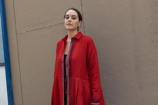 Fall in love with Injiri's coats! Completely handmade, this model comes in a scarlet red tone and features half sleeves and it is a knee-length dress. It closes with front buttons and features hand embroidery in various parts of the garment.