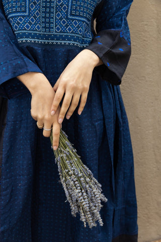 Fall in love with Injiri's dresses! Completely handmade, this midi model comes in an indigo blue shade with white hand-embroideries and it features long wide sleeves. Pleats at the waist provide more volume at the bottom.