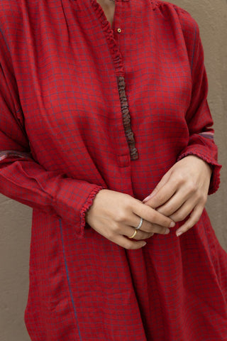A long shirt to wear on any occasion, handmade entirely from merino wool. It comes in red, perfect for adding a touch of colour to your outfit. It features front buttons to close the garment and hand-sewn ornaments typical of Indian tradition. 