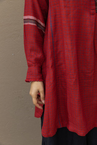 A long shirt to wear on any occasion, handmade entirely from merino wool. It comes in red, perfect for adding a touch of colour to your outfit. It features front buttons to close the garment and hand-sewn ornaments typical of Indian tradition. 