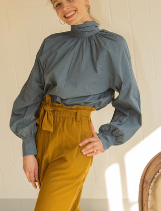 This blouse comes in a unique and eye-catching colour, a blue tending to grey - easy to match with many colours. The Georgia Shirt has a soft shape due to the draping that it has and it features a turtle neck. It was entirely made by hand from popelin cotton.
