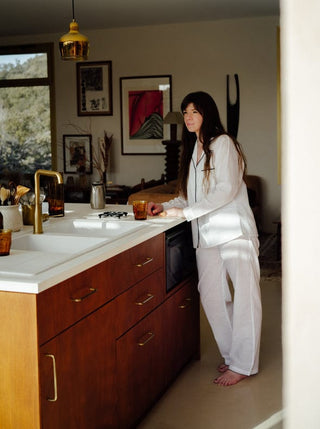 An absolute must-have in your sustainable wardrobe: Scarlette Ateliers' white pyjama to put on when you get out of the bath - a delicate touch that will pamper your skin. Handwoven from pure pristine white cotton on wooden looms in South India, this set consists in a long-sleeved jacket and soft trousers with contrasting blue bias finish.
