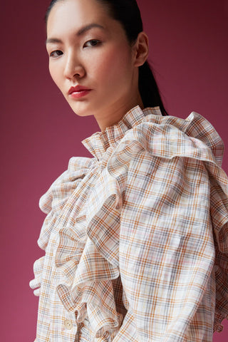 The absolute piece for a very delicate look. This checkered shirt made from deadstock fabric comes with ruffles, oro chiaro plated buttons and elastic cuffs.