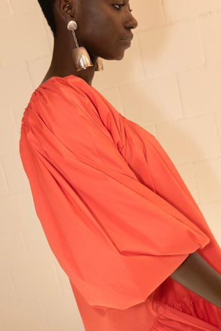A piece of clothing that can not miss in your suitcase for your summer getaways. Made exclusively in Europe from pure cotton, this short dress features a one-shoulder design that is made unique by the balloon mono-sleeve. It comes in a coral shade and is therefore perfect for summer. 