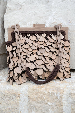 Sempre frame Woyoyo bag is extravagant at glance, decorated with a composition of selected scales made of Georgian walnut heartwood. It has a Woyoyo flat kiss-lock mechanism and handstitched inside pocket. The handle is made as a blend between handmade wooden chain combined with a handknitted soft hold.